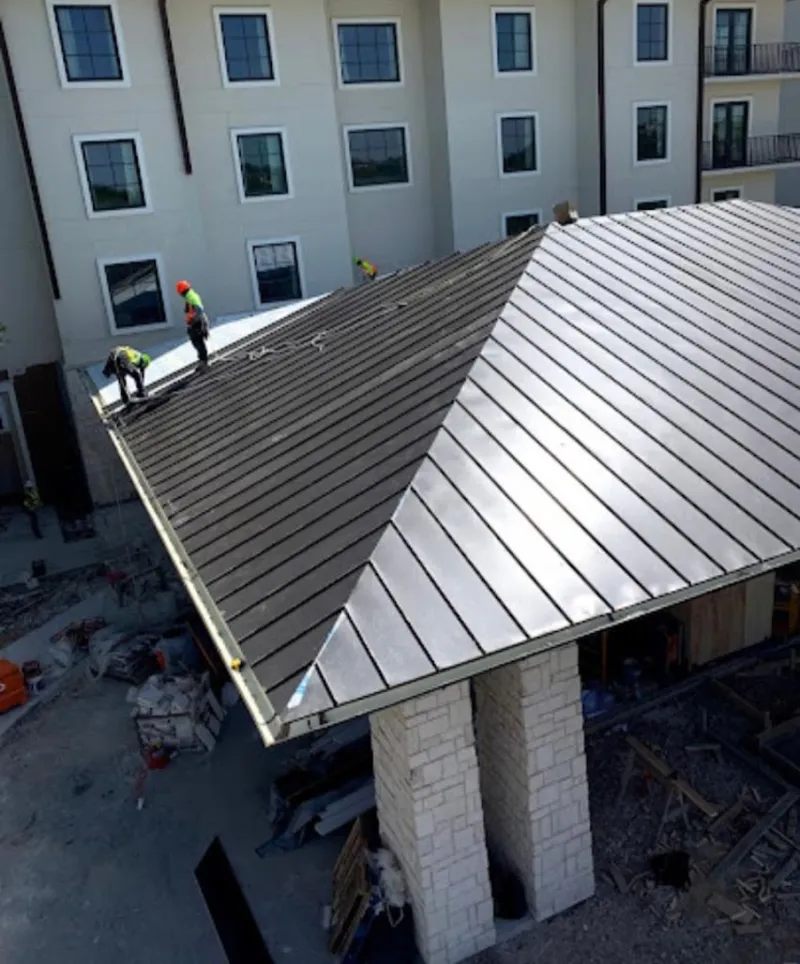 Crew installing standing seam metal roof panels on a commercial project in Humboldt